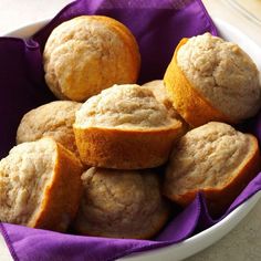 a white bowl filled with muffins on top of a table