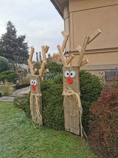 two wooden reindeer heads are standing in the grass