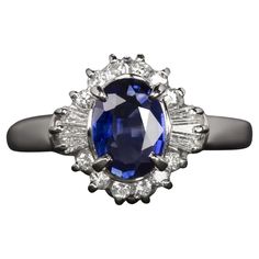 This elegant cocktail ring features a rich blue sapphire surrounded by a halo of round and baguette cut diamonds. Highlights: - 1.03ct natural sapphire center with a very well saturated blue hue - 0.28ct of very bright white and completely eye clean F-G VS1-SI1 diamonds - High quality platinum setting Dimensions: 11.8mm across (north-south) and 7.7mm from the finger to the top of the ring. Oval Sapphire Ring, Platinum Diamond Rings, Jewels Rings, Contemporary Ring, Family Jewellery, Blue Sapphire Diamond, Diamond Cocktail Rings, Baguette Cut Diamond, Modern Ring