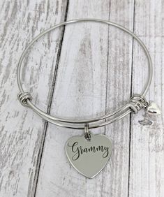 "This is an stainless steel bangle bracelet with an 18mm stainless steel heart charm that reads, \"Grammy.\" All items will arrive boxed and ready for gift giving." Mother's Day Gift Stainless Steel Name Bracelet, Mother's Day Engraved Stainless Steel Charm Bracelet, Mother's Day Stainless Steel Name Bracelet, Personalized Stainless Steel Charm Bracelet As Gift, Heart-shaped Stainless Steel Charm Bracelet For Anniversary, Personalized Hypoallergenic Heart Bracelet For Mother's Day, Heart-shaped Stainless Steel Charm Bracelet For Mother's Day, Personalized Hypoallergenic Stainless Steel Jewelry, Engraved Stainless Steel Charm Bracelet As Gift