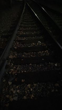 an empty train track in the dark at night