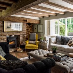 a living room filled with furniture and a fire place in the middle of it's walls