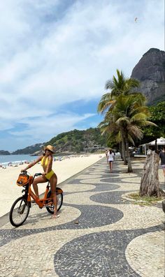 a woman riding a bike on the beach