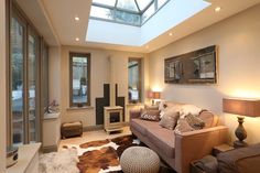 a living room filled with furniture and a skylight