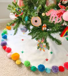 a christmas tree skirt with pom - poms on the bottom and decorations around it