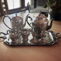 a silver tea set sitting on top of a metal tray