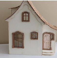 a white doll house with two windows and a door