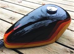 a black and orange helmet sitting on top of a wooden table