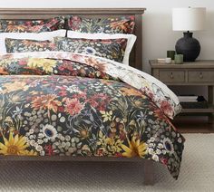 a bed with a floral comforter and pillows