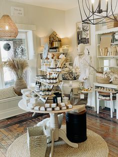 a room filled with lots of different items on top of a white table next to a window