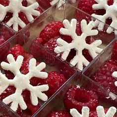 raspberries with white snowflakes on them in small glass containers, ready to be eaten