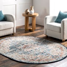 a living room area with two chairs and a rug on the floor in front of a table