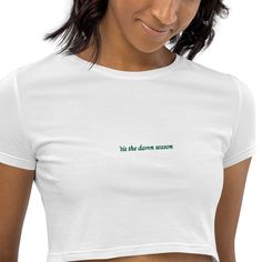 Cute and minimalist 'tis the damn season white and green embroidered crop top perfect for the holiday season! If you are interested in a custom color or design then please reach out! The organic crop top is soft, comfy, and what's more, made of 100% organic cotton. This premium crop is bound to become a favorite for every eco-conscious buyer.  🤎 Product Details: * Material: 100% organic cotton * Fabric weight: 4.42 oz/yd² (150 g/m²) * Slim fit * Side-seamed construction * Blank product sourced from Latvia 🤎 Unique Designs: All designs are uniquely created and printed onto our apparel. Our designs are meant to inspire and comfort, so if you would like to make any adjustments to further please you or personalize, don't hesitate to reach out! With the exception of hats, which are embroidere Embroidered Fitted Casual Crop Top, Casual Embroidered Fitted Crop Top, Casual Embroidered Cropped Top, White Embroidered Cropped Top, White Embroidered Cropped Crop Top, Tis The Damn Season, Embroidered Crop Tops, Cropped Tops, Organic Cotton Fabric