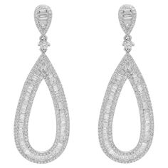 These exemplary earrings mounted in 18k white gold add a touch of elegance and sophistication to any outfit. Featuring, channel set baguette cut and pave set round cut diamonds weighing 3.31 carats. Diamond quality: color G-H and clarity VS-SI. A one-of-a-kind ultra-sparkler timeless piece. Earring length: 1.9 inches. Total weight: 8.18 grams. Secured with push back post closure. Comes with a presentable gift box. American Modern, Statement Drop Earrings, Diamond Drops, Diamond Drop Earrings, Diamond Design, Round Cut Diamond, Timeless Pieces, Statement Earrings, Round Cut