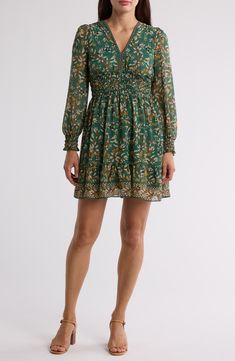 A smocked waist shapes the silhouette of this floral-patterned dress framed by long sleeves. 35 1/2" length V-neck Long sleeves with smocked cuffs Slips on over head Lined 100% polyester Machine wash, line dry Imported Model stats: 5'10" height, 32" bust, 25" waist, 36" hip. Model is wearing size Small. Casual Long Sleeve Smocked Dress With Floral Print, Green Smocked Long Sleeve Dress For Fall, Green Long Sleeve Smocked Dress For Fall, Fitted Long Sleeve Smocked Dress With Floral Print, Green Long Sleeve Dress With Smocked Cuffs, Casual Long Sleeve Smocked Dress With Elastic Waistband, Green Smocked Dress With Long Sleeves, Bohemian Long Sleeve Smocked Dress, Green Fitted Smocked Dress With Long Sleeves