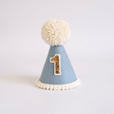 A special little accessory to celebrate a big occasion! Perfect for Cake Smash photoshoots or that special touch to a 1st Birthday outfit, costumes and dress ups.  DETAILS ♕  1 x 100% Merino Wool Felt Party Hat. Finished with mini pom trim, number of choice and wool Pom.  (any number available, not just for 1st Birthdays. Please select number) Elastic comes attached to wear around back of head. ♕ Matching "One" cake topper to go with handmade hat available. Select this option in the drop down to Fun Birthday Party Hat Supplies, Playful Blue Hat For First Birthday, Playful Blue Hat For Gift, Playful Blue Hat As A Gift, Playful Blue Hats For Gifts, Playful Blue Hat As Gift, Fun Blue Hats For Gifts, Fun Blue Hat For Gift, Fun Blue Hat