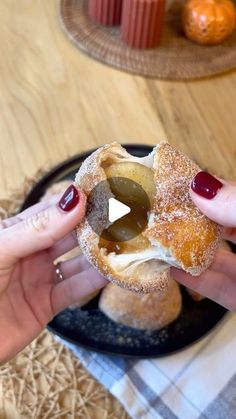 two hands holding a donut with olives on it