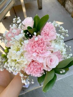 a bouquet of pink and white flowers sitting on top of a chair