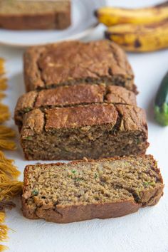 two slices of banana bread sitting on top of a white counter next to some bananas