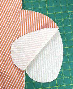 an orange and white striped piece of fabric next to a green cutting board with scissors