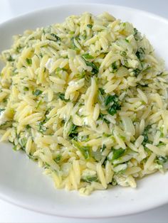 a white plate topped with pasta and greens