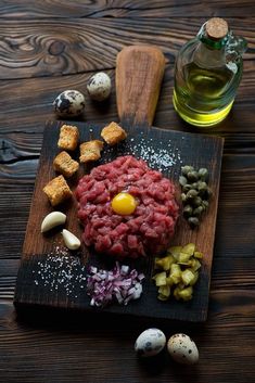 an assortment of food on a wooden cutting board