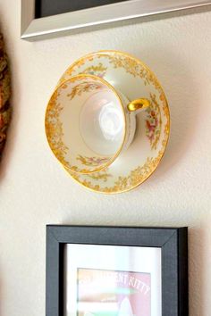 a coffee cup and saucer sitting on top of a table next to a framed photograph