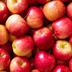 a pile of red and yellow apples sitting next to each other