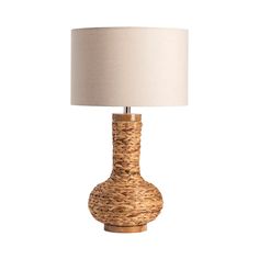 a table lamp with a white shade on it and a wooden base in the shape of a vase