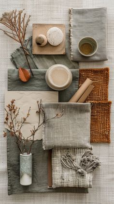 an assortment of items are arranged on a table cloth, including napkins, cups and saucers