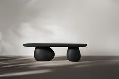 a black table sitting on top of a wooden floor next to a white and gray wall