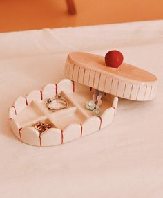 two small trays on top of a bed with rings and ring boxes in them