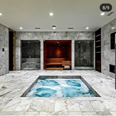 an indoor hot tub in the middle of a room with marble walls and flooring