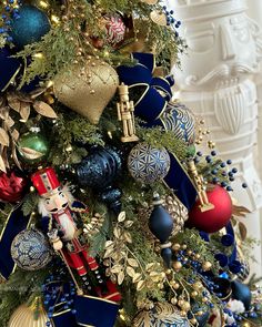 a christmas tree with ornaments and decorations on it's branches, including a nutcracker ornament