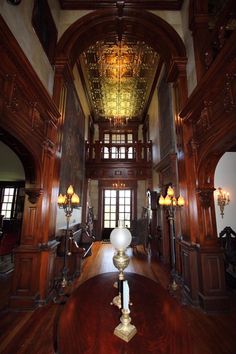 a large wooden room with chandeliers and windows