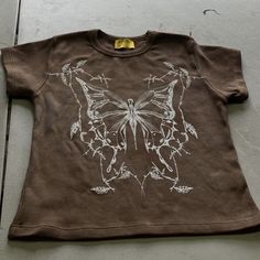 a brown t - shirt with a butterfly drawn on it