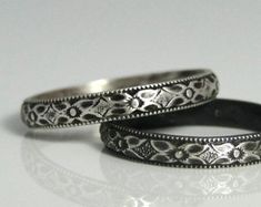 two silver wedding rings sitting next to each other