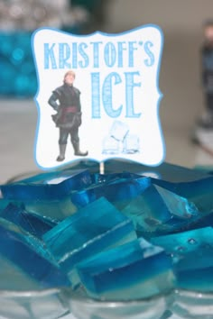 a glass bowl with ice cubes in it and a sign that says kristoff's ice