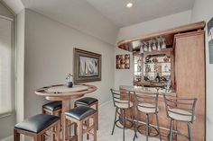 a bar with stools in a kitchen next to a cabinet and counter top area