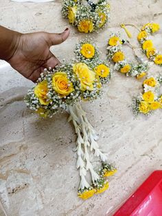 someone is arranging yellow and white flowers on the counter top for their wedding bouquets