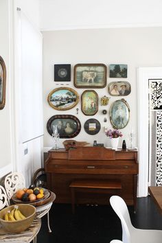 a living room filled with furniture and pictures on the wall next to a wooden piano