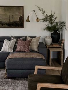 a living room filled with lots of furniture next to a wall mounted painting on the wall