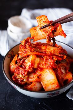 a bowl full of food with chopsticks sticking out of it