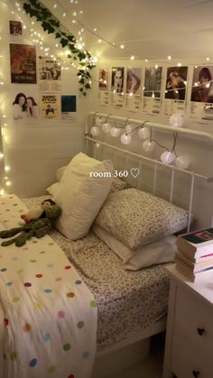 a bedroom with lights strung from the ceiling and pictures on the wall above the bed