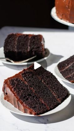 two plates with slices of chocolate cake on them and one slice has been cut from it