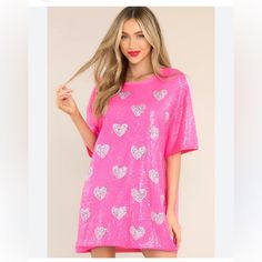 Color Hot Pink. Running Oversized. Look Radiant In This Stunning Blushing Hearts Dress! Made With Beautiful Pink Sequins And Contrasting Heart Design, It'll Make You Shine With Style. With Its Short Sleeves And Round Neck, It's The Perfect Way To Show Off Your Unique Flair. Sparkle Away! Heart Shaped Tops For Summer Parties, Heart-shaped Party Tops For Summer, Heart-shaped Summer Party Tops, Summer Party Top With Heart Print, Pink Heart Print Short Sleeve Dress, Pink Crew Neck Party Dress, Pink Short Sleeve Dress With Heart Print, Casual Crew Neck Sequin Dress, Spring Mini Dress With Sequins And Short Sleeves