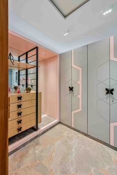 an empty room with pink and grey walls in the center, along with a wooden chest of drawers