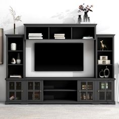 a large entertainment center with shelves and a flat screen tv on the wall in an empty room