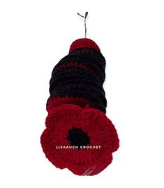 a red and black crochet flower hanging from a string