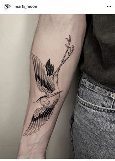 a woman's arm with a bird and arrow tattoo on the left side of her arm